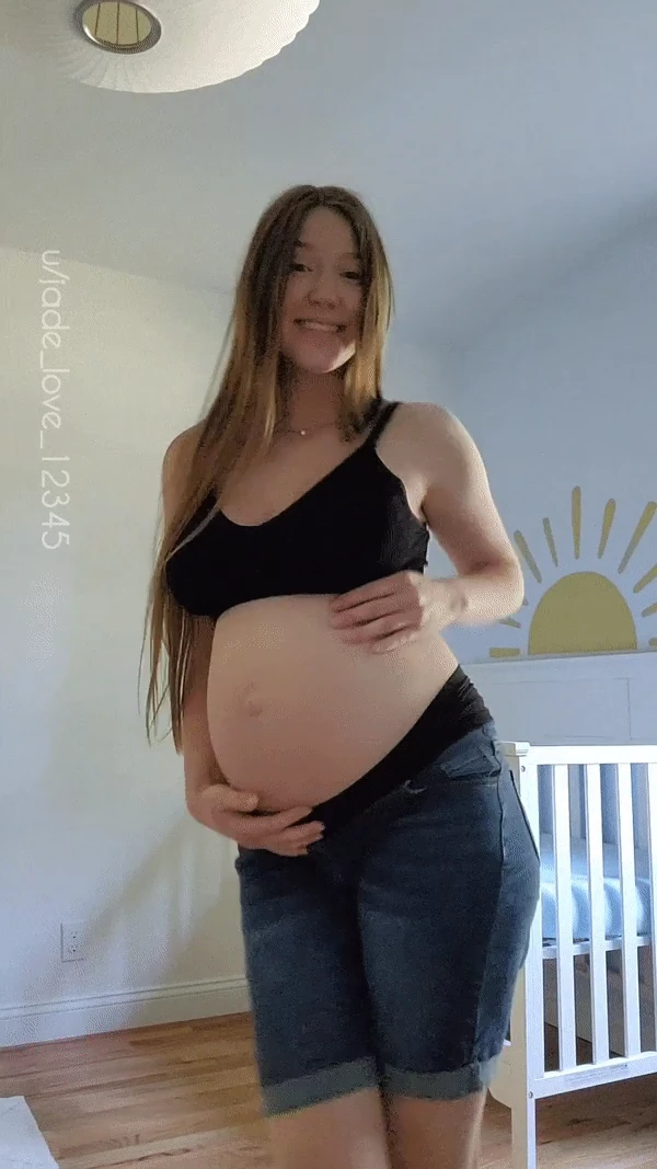Showing off my baby bump in the nursery